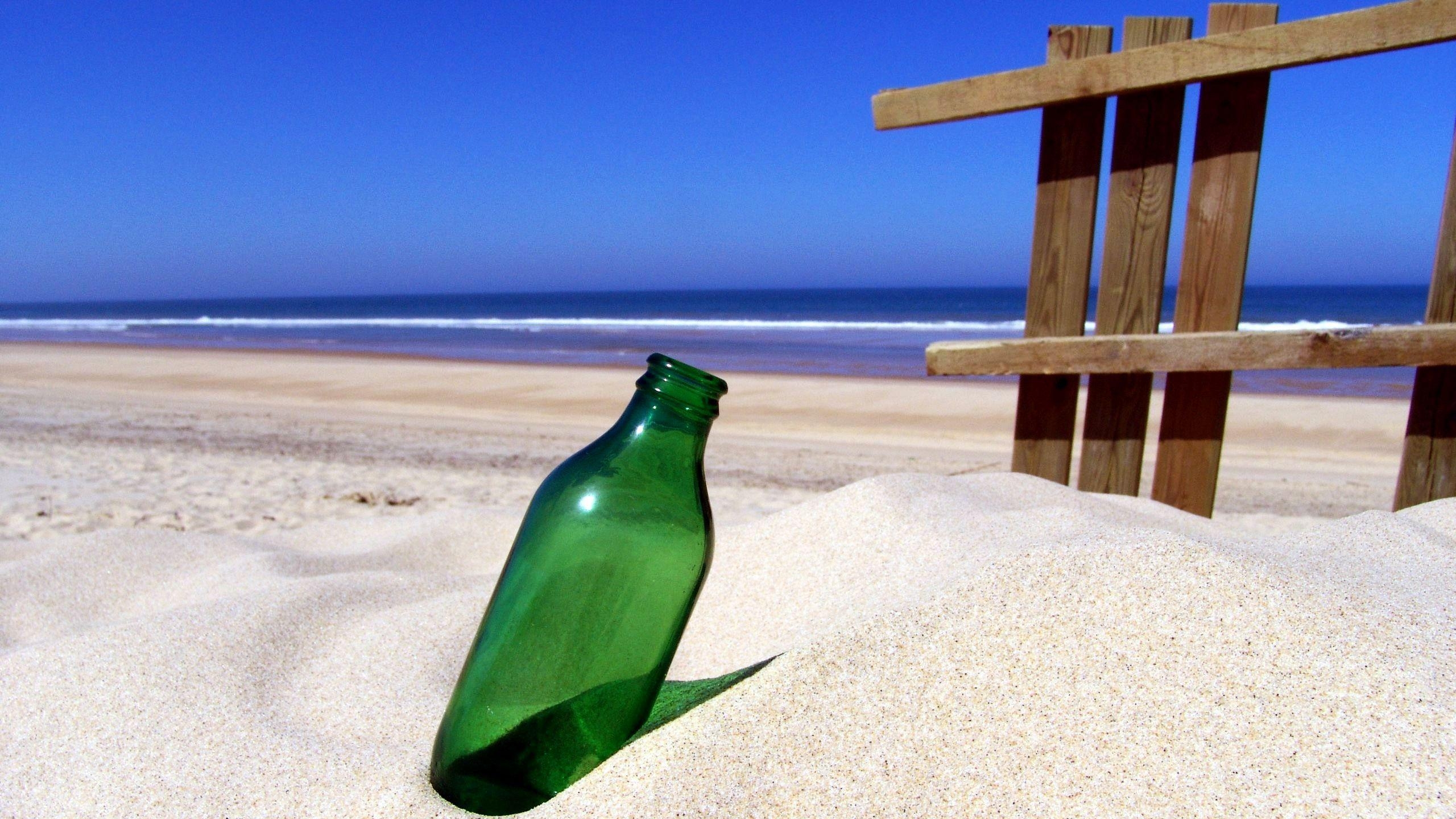 2560x1440 Green bottle on sandy beach wallpaper, Desktop