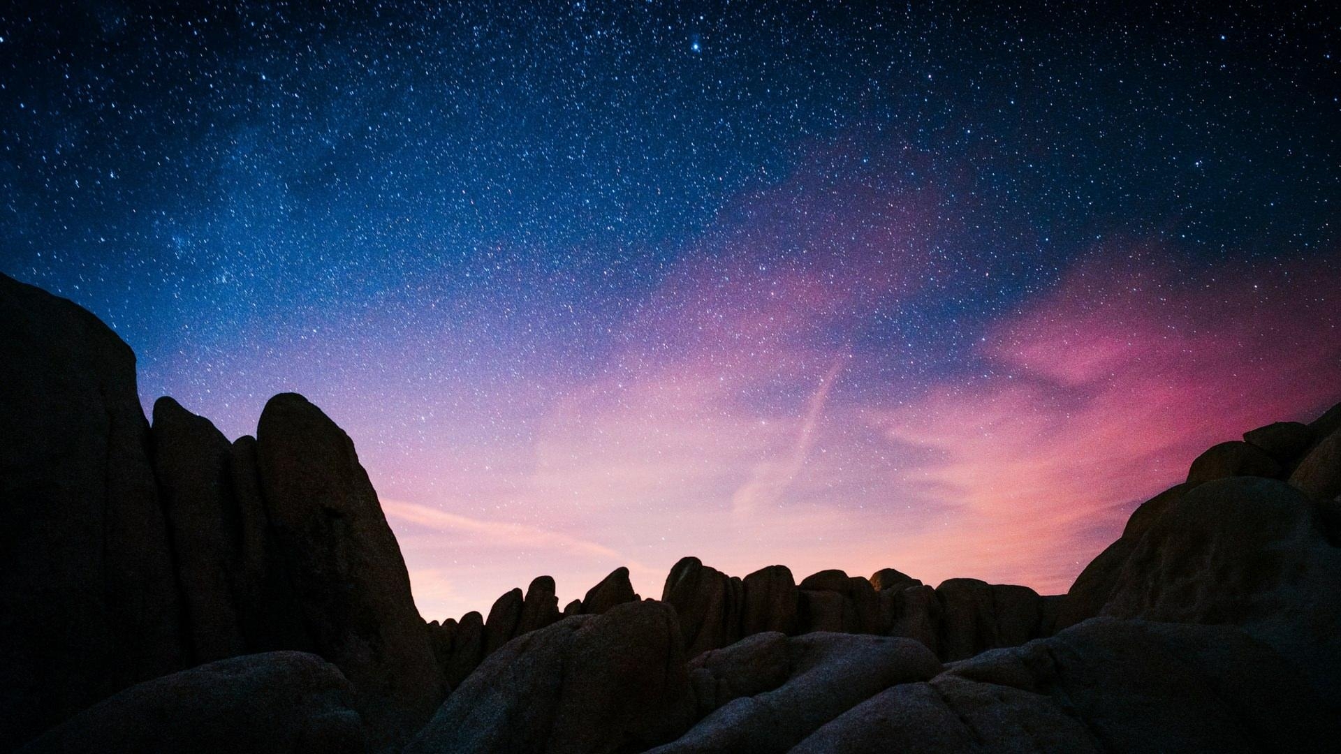 1920x1080 The sky full of stars with blue and pink hues over the rock, Desktop