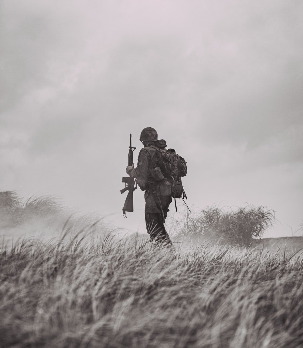 1000x1150 grayscale photo of man in black jacket and pants holding rifle photo, Phone