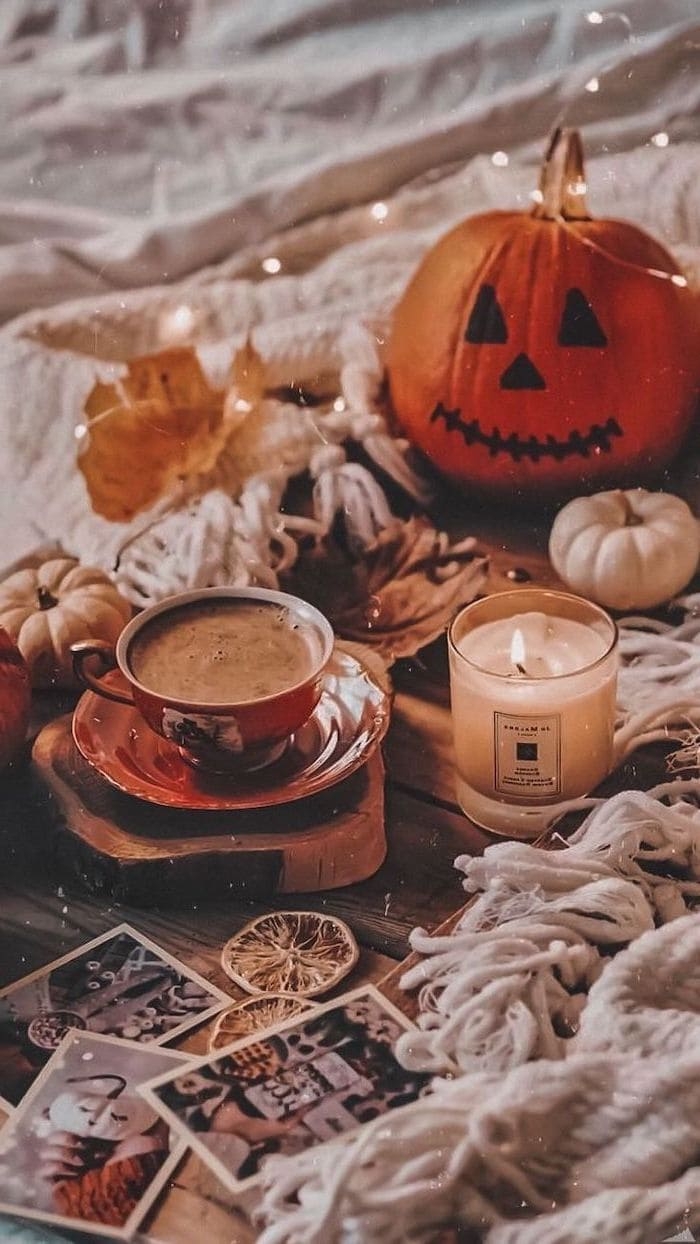 700x1250 coffee cup next to lit candle carved pumpkin placed on wooden floor with white blankets aesthetic fall wallpaper, Best iPhone Wallpaper and iPhone background, WallpaperUpdate, Best iPhone Wallpaper and, Phone