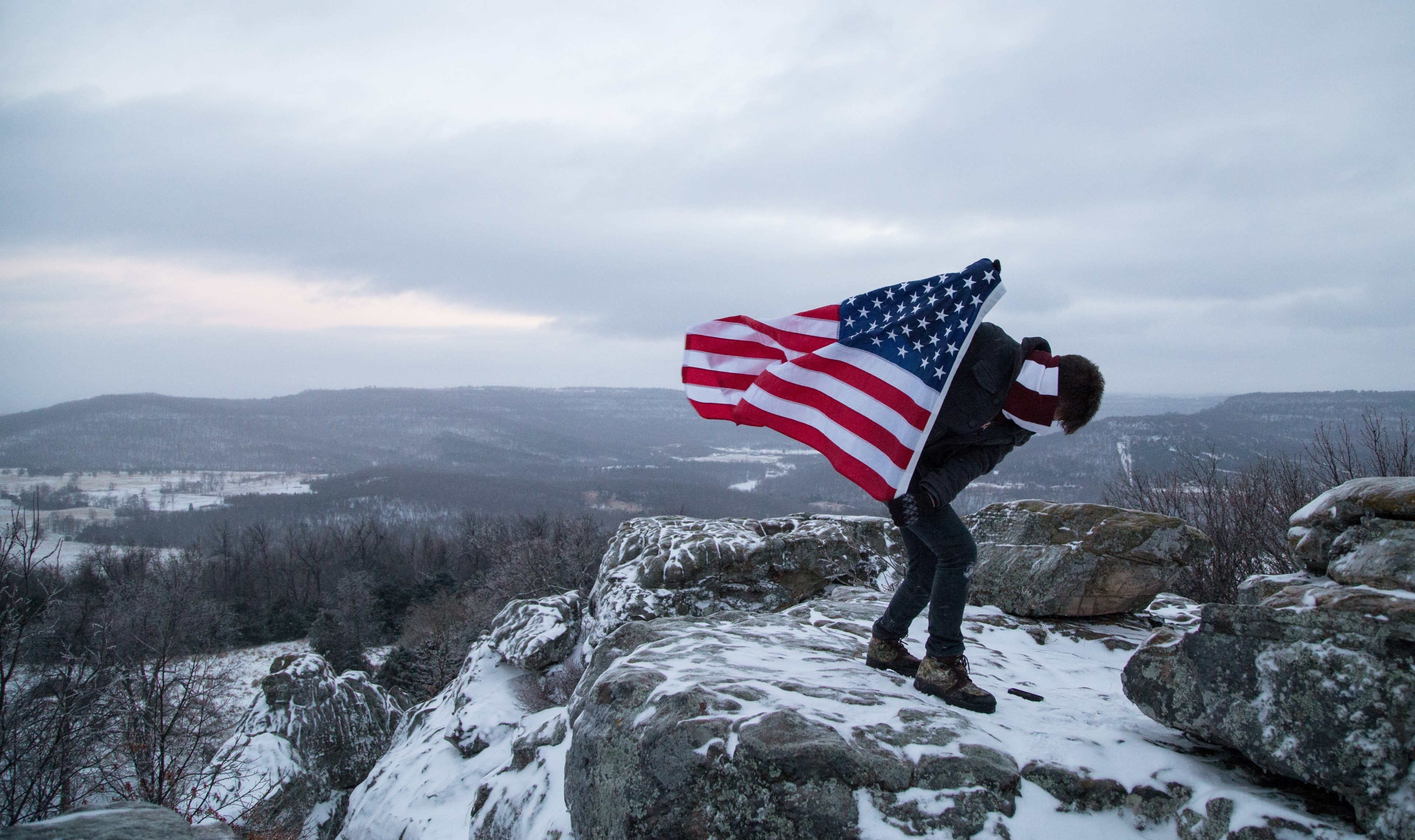 3840x2280 a climber holds the american flag while standing on the peak of a, Desktop