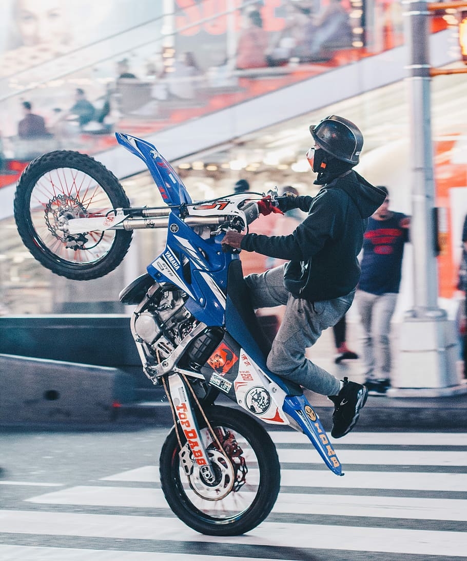 910x1100 HD wallpaper: selective focus photography of man doing wheelie on motocross dirt bike, man riding blue and white Yamaha dirt bike, Phone