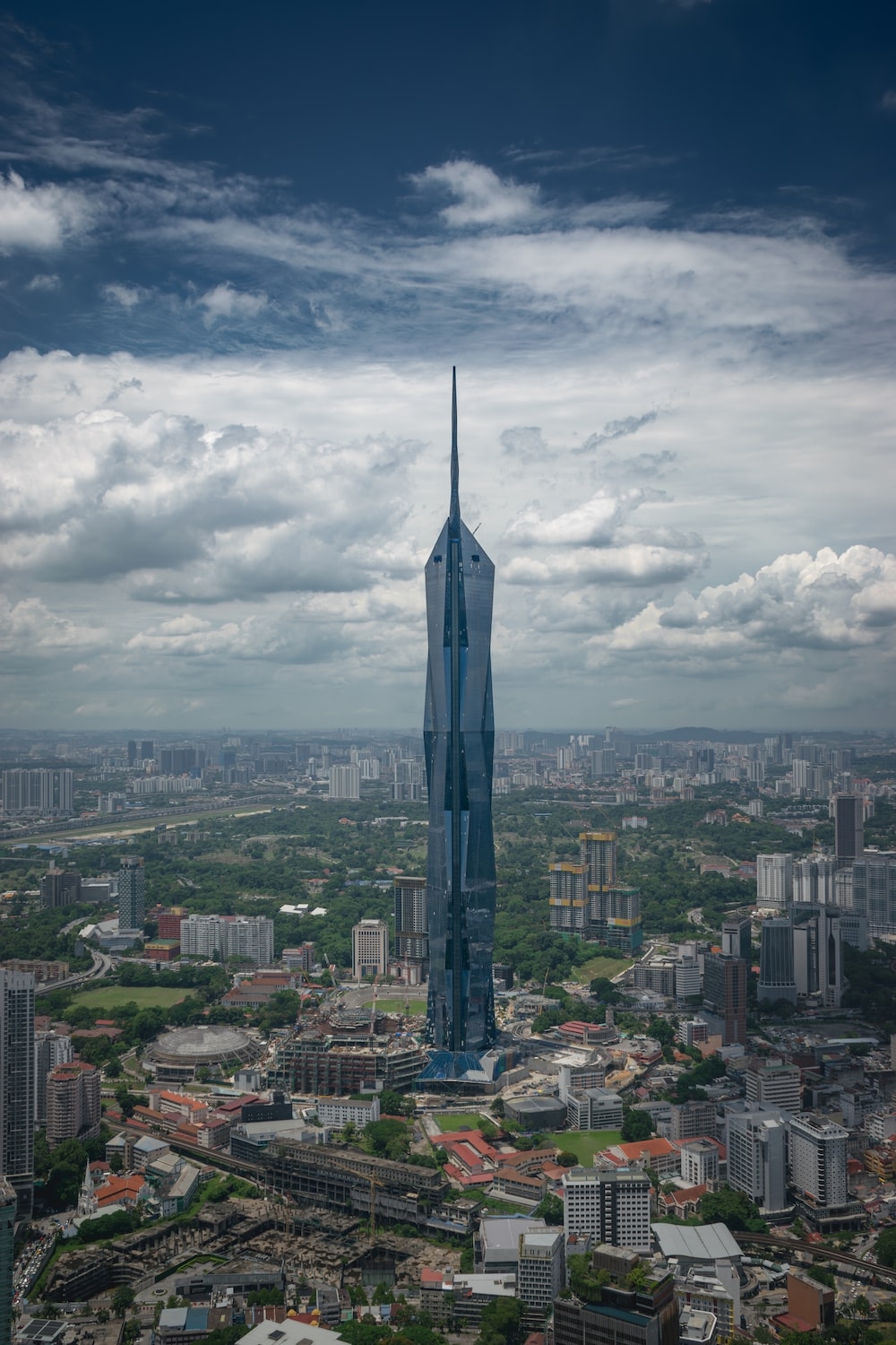 1000x1500 A tall building towering over a city under a cloudy sky photo, Phone